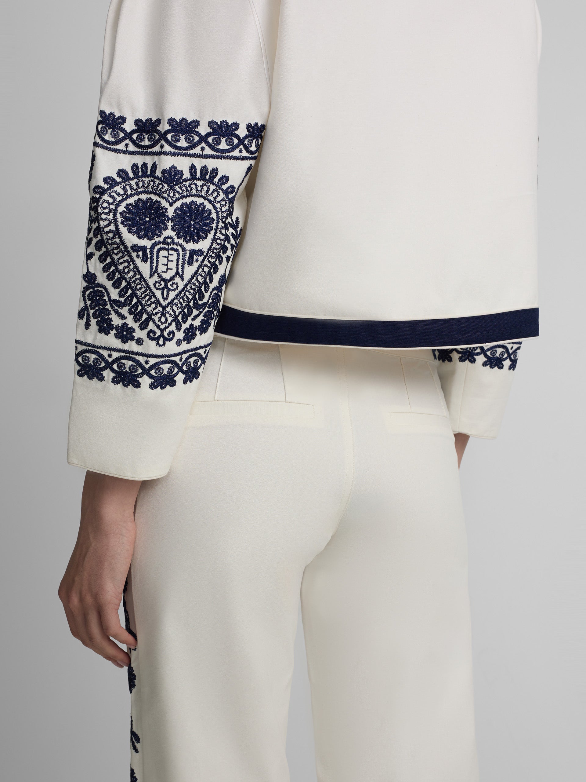 Straight pants with embroidered details in white