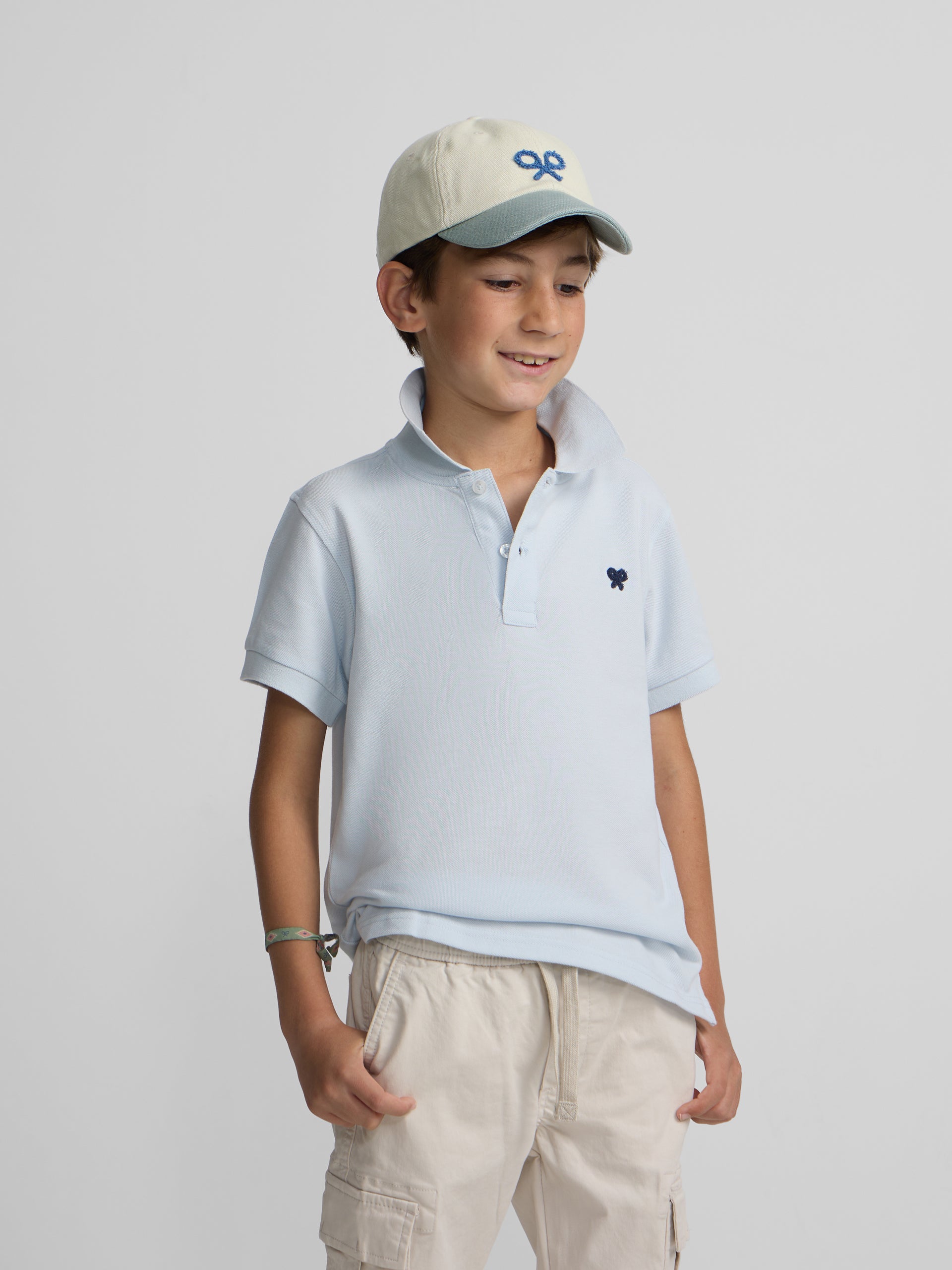 Polo enfant uni logo bouclé bleu clair