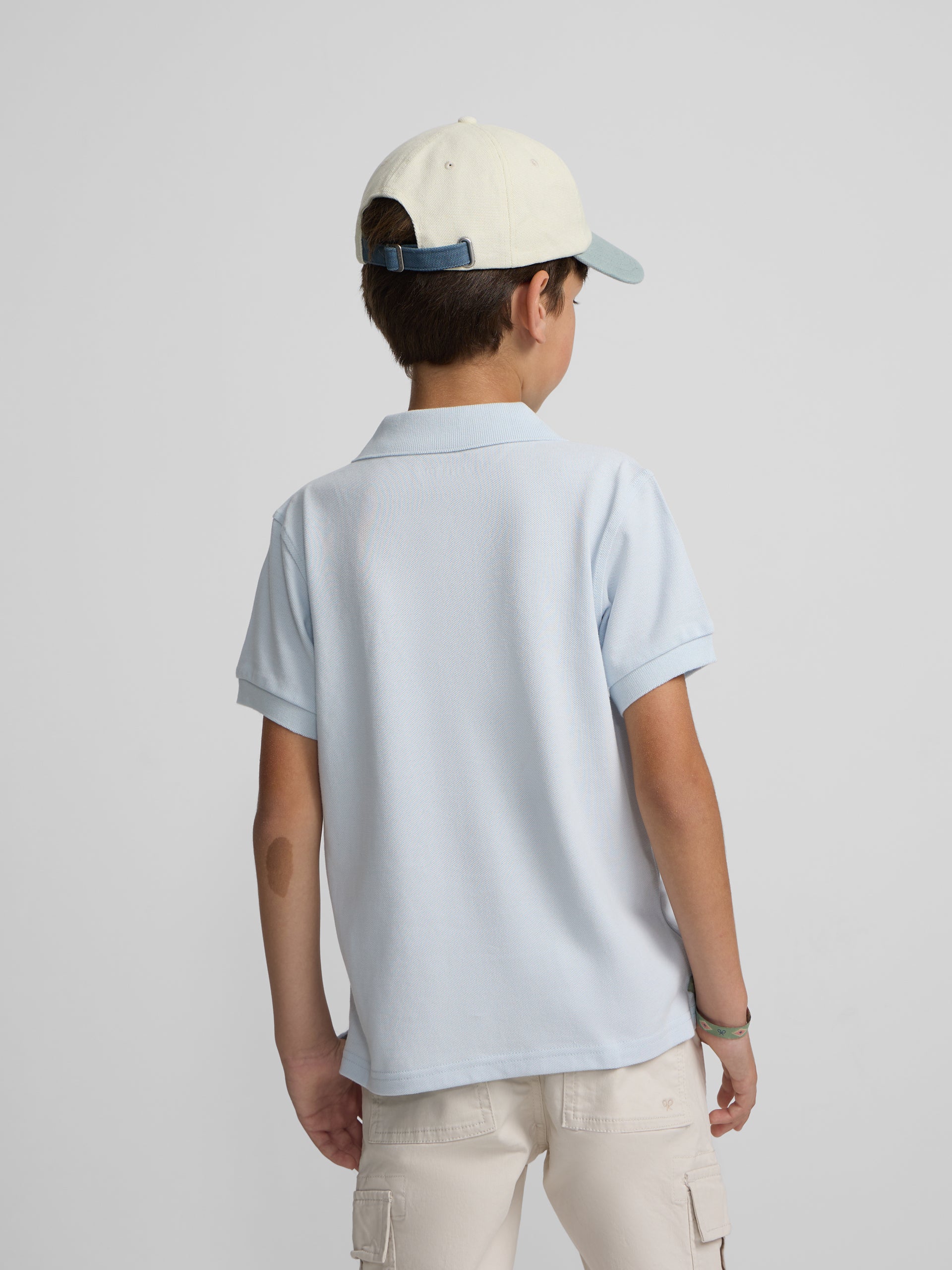 Polo enfant uni logo bouclé bleu clair