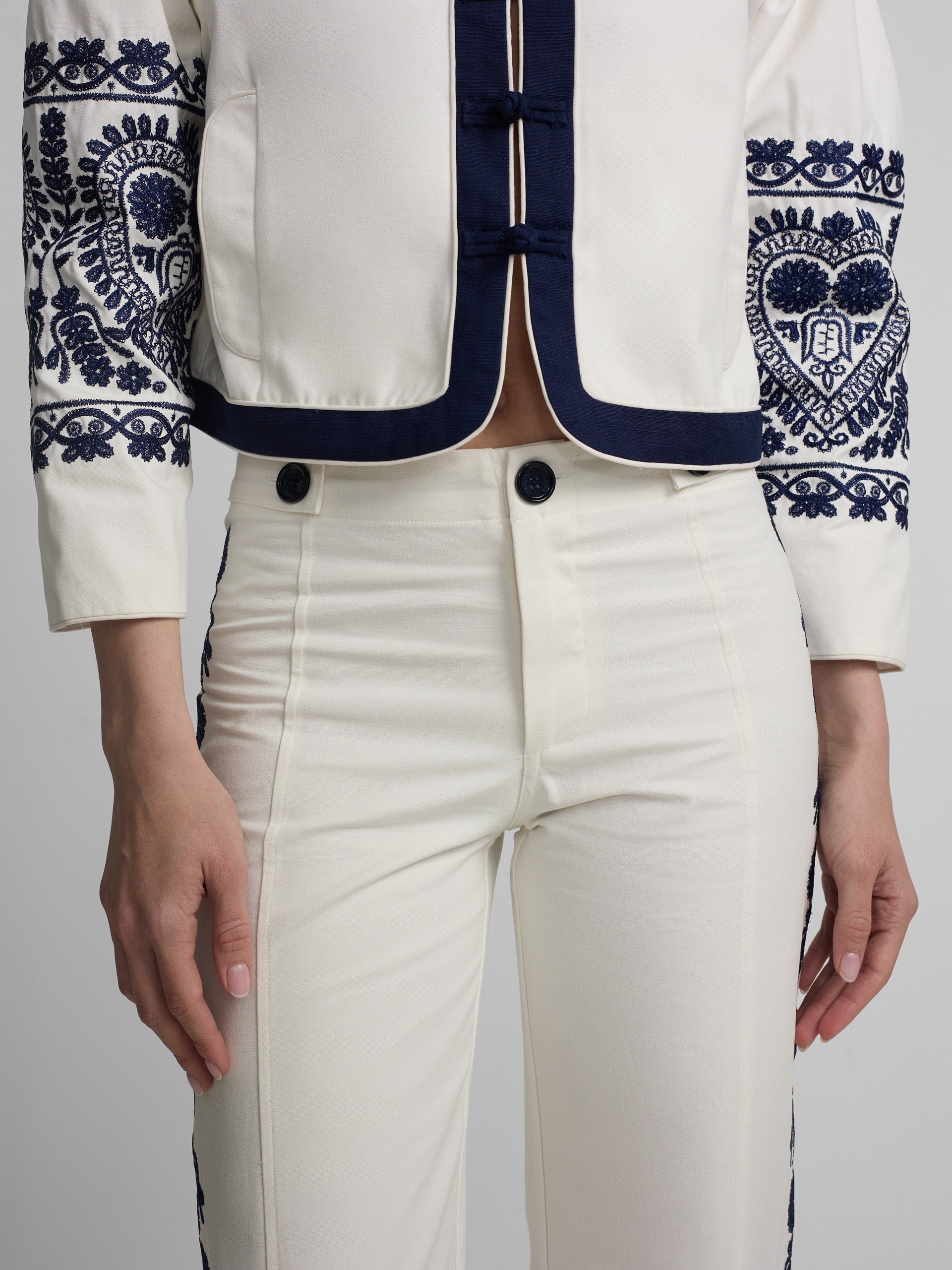 Straight pants with embroidered details in white